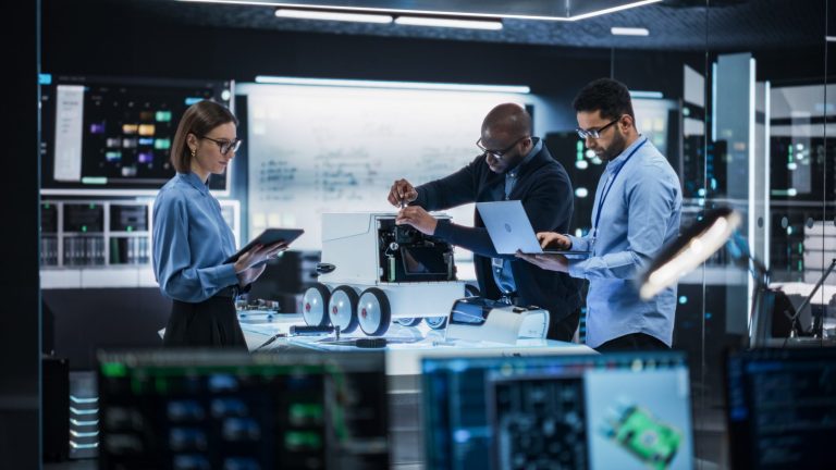 Diverse,Team,Of,Industrial,Robotics,Specialists,Gathered,Around,A,Table